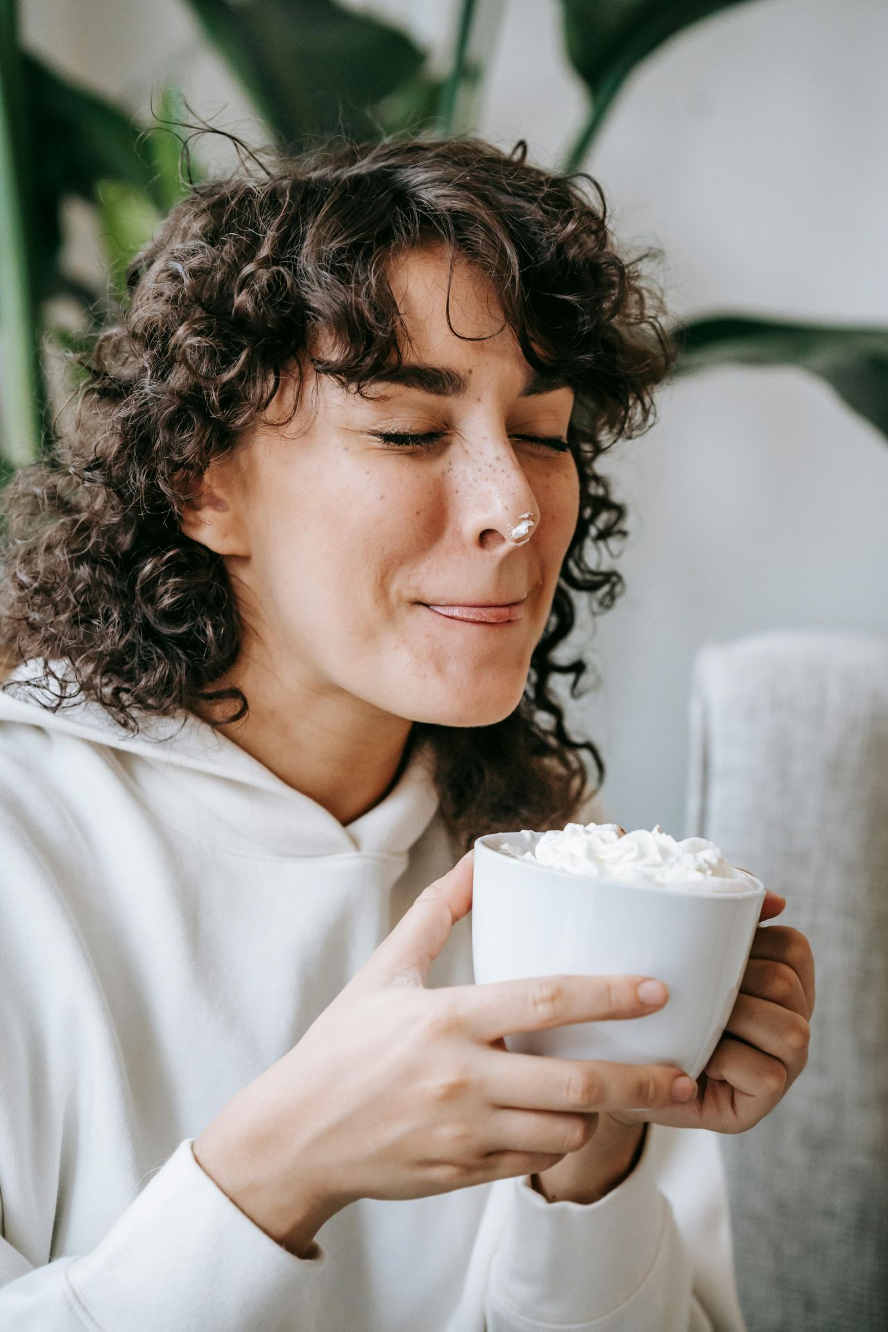 Frau beim Kakaotrinken mit Sahne
